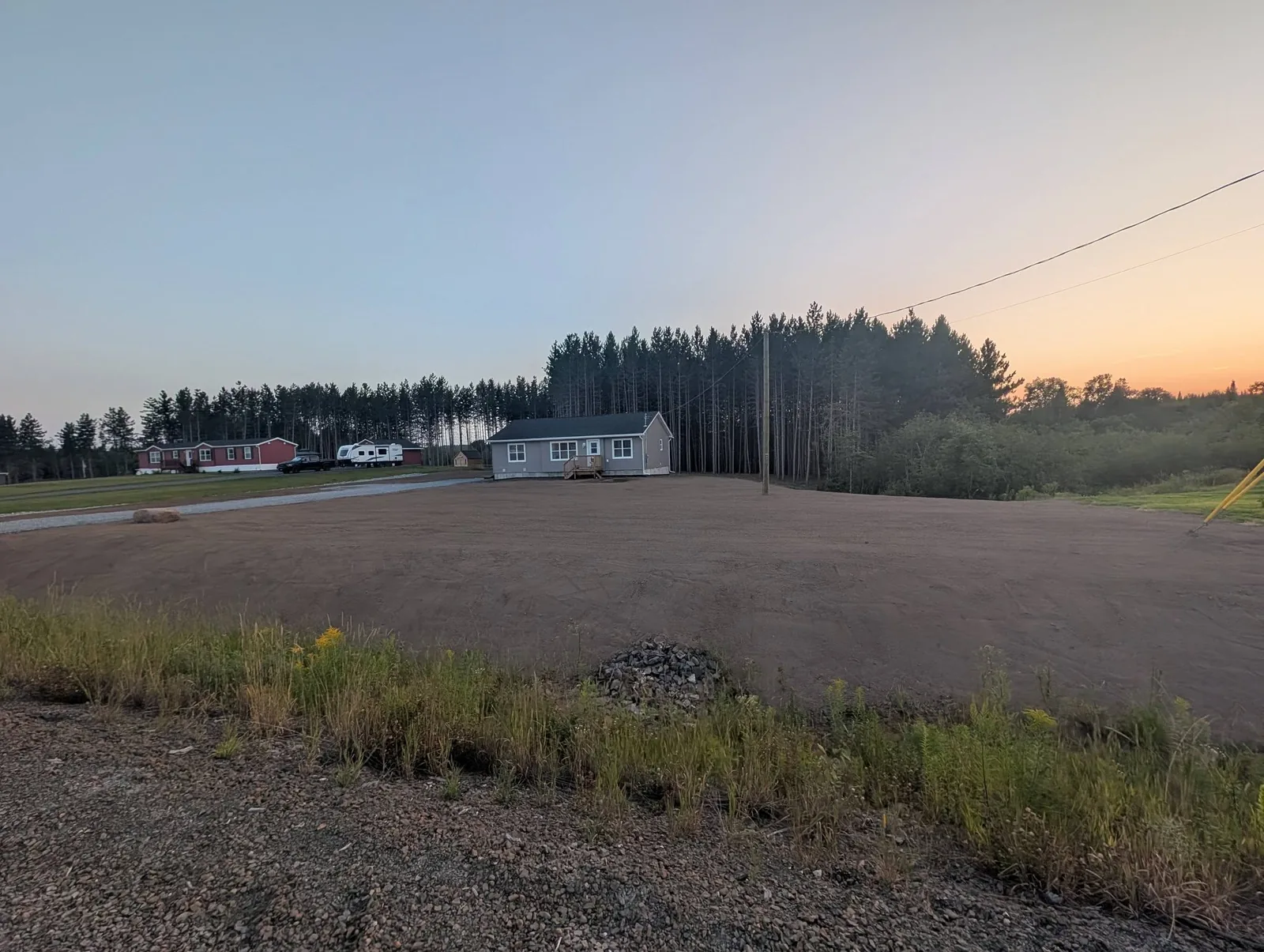 Reshaped front yard with fresh soil after grading and ditch work