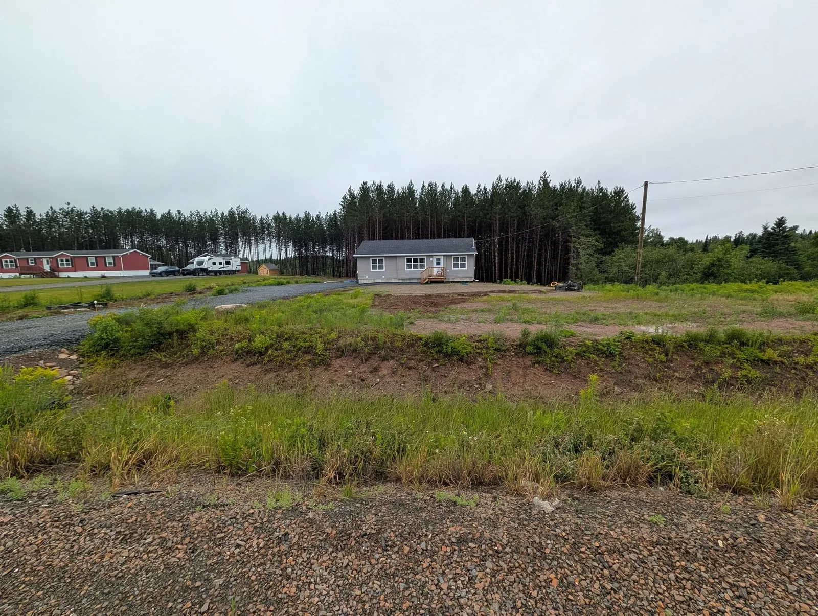 Uneven front yard and steep roadside ditch before grading